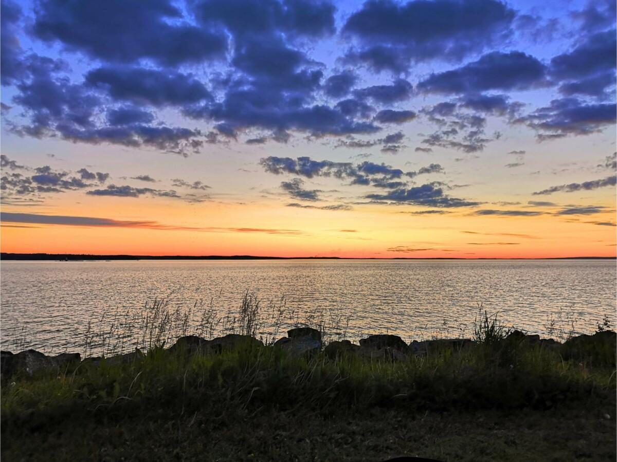 Juhannusyön sinertävät pilvet ja vaaleana hohtava taivaanranta Näsijärven rannalla.